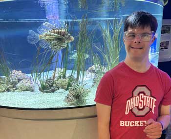 Programs-Home-Page Young Adult Male standing in front of aquarium